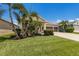 Gorgeous home featuring lovely manicured landscaping, a bright green lawn, and beautiful palm trees at 11513 11Th E Ave, Bradenton, FL 34212