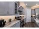 Well-lit kitchen with gray cabinets, stainless steel appliances, subway tile backsplash, and marble countertops at 11513 11Th E Ave, Bradenton, FL 34212