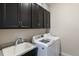 Laundry room featuring modern appliances, sleek cabinets, granite countertops, and a utility sink at 11513 11Th E Ave, Bradenton, FL 34212