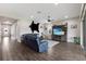 Living room with wood-look tile flooring, a large blue sectional sofa, television, and access to the front entrance at 11513 11Th E Ave, Bradenton, FL 34212