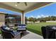 Covered patio with outdoor seating and a grill overlooking the pool and expansive lawn at 11513 11Th E Ave, Bradenton, FL 34212