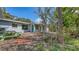 Backyard featuring lush green landscaping and trees with a picnic table near an attached room at 120 Hammock Rd, Anna Maria, FL 34216