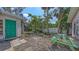 Green door in the backyard landscaping with a picnic table against a white fence backdrop at 120 Hammock Rd, Anna Maria, FL 34216