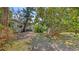 Exterior shot showcasing the yard with native trees and foliage at 120 Hammock Rd, Anna Maria, FL 34216