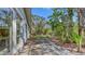 View of a lush, private backyard with mature trees and patio at 120 Hammock Rd, Anna Maria, FL 34216