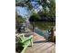 Beautiful backyard dock with lovely chairs and views of calm waters surrounded by lush greenery at 120 Hammock Rd, Anna Maria, FL 34216