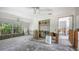 Spacious living room featuring large windows with backyard view, ceiling fans, and renovation potential at 120 Hammock Rd, Anna Maria, FL 34216