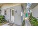 Side exterior view showcasing a walkway to the bright green door, lantern lighting, and tropical greenery at 120 Hammock Rd, Anna Maria, FL 34216