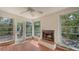 Bright sun room featuring tile flooring, a fireplace, and large windows with views of the backyard at 120 Hammock Rd, Anna Maria, FL 34216