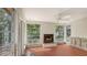 Sun room with fireplace, tile floor, bright windows and views of the landscape at 120 Hammock Rd, Anna Maria, FL 34216