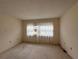 Simple bedroom with neutral carpet, a large window, and a bright, airy feel at 1214 56Th W St # 1214, Bradenton, FL 34209