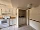 Functional kitchen space featuring white cabinets, appliances, and convenient in-closet laundry setup at 1214 56Th W St # 1214, Bradenton, FL 34209