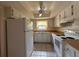 Bright kitchen with white appliances, ceiling fan, and tile flooring for easy maintenance at 1214 56Th W St # 1214, Bradenton, FL 34209