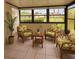 Sunroom with tile flooring and views of the well-maintained community grounds and palm trees at 1214 56Th W St # 1214, Bradenton, FL 34209