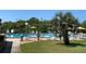 Relaxing swimming pool with plenty of lounge chairs, umbrellas, and a tropical palm tree at 1214 56Th W St # 1214, Bradenton, FL 34209