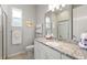Well-lit bathroom with granite countertop, white cabinets, and a glass-enclosed shower for a clean, modern look at 12339 Glenridge Ln, Parrish, FL 34219
