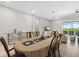 Dining area featuring a large table and chairs adjacent to a sunny living room and large screened windows at 12339 Glenridge Ln, Parrish, FL 34219