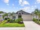 Charming single-Gathering home with a two-car garage and a well-manicured lawn and landscaping with several palm trees at 12339 Glenridge Ln, Parrish, FL 34219