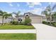 Charming single-Gathering home with a two-car garage and a well-manicured lawn and landscaping with several palm trees at 12339 Glenridge Ln, Parrish, FL 34219