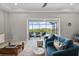 Comfortable living room with blue armchairs and a sliding glass door, leading to an outdoor pool and backyard at 12339 Glenridge Ln, Parrish, FL 34219