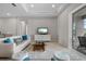 Bright living room featuring a comfortable white sofa and sliding glass doors leading to the backyard pool at 12339 Glenridge Ln, Parrish, FL 34219
