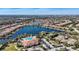 Aerial view of community with a large lake, pool, clubhouse, tennis courts, and houses with red tiled roofs at 12822 Del Corso Loop, Bradenton, FL 34211