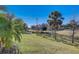 Scenic backyard view featuring a pond, green space, and palm trees under a blue sky at 12822 Del Corso Loop, Bradenton, FL 34211