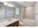 Bathroom features a shower-tub combo, vanity, and a large mirror with neutral paint at 12822 Del Corso Loop, Bradenton, FL 34211