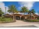 Beautiful clubhouse with red tiled roof, stone accents, well manicured landscaping, and palm trees at 12822 Del Corso Loop, Bradenton, FL 34211