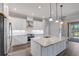 Modern island kitchen featuring white cabinets, stainless steel appliances, granite countertops, and hardwood flooring at 12822 Del Corso Loop, Bradenton, FL 34211