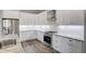 Bright island kitchen featuring white cabinets, stainless steel appliances, granite countertops, and hardwood flooring at 12822 Del Corso Loop, Bradenton, FL 34211