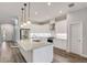 Modern island kitchen featuring white cabinets, stainless steel appliances, pendant lighting, and hardwood flooring at 12822 Del Corso Loop, Bradenton, FL 34211
