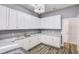 Laundry room featuring white cabinets, light countertops, modern light fixture and stainless steel faucet at 12822 Del Corso Loop, Bradenton, FL 34211