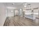 Spacious living room showcasing hardwood floors, recessed lighting, elegant chandeliers, and an open kitchen concept at 12822 Del Corso Loop, Bradenton, FL 34211