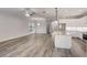 Bright, open living room with hardwood floors, chandeliers, and an island kitchen with stainless steel appliances at 12822 Del Corso Loop, Bradenton, FL 34211