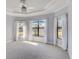 Light-filled main bedroom with tray ceiling, ceiling fan, and large windows providing scenic views at 12822 Del Corso Loop, Bradenton, FL 34211