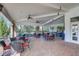 Outdoor seating area with tables, chairs, fans, and a brick fireplace with an outdoor grill at 12822 Del Corso Loop, Bradenton, FL 34211