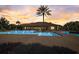 Stunning community pool with lounge chairs, palm trees, and clubhouse at sunset at 12822 Del Corso Loop, Bradenton, FL 34211