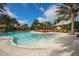 Large community swimming pool featuring lounge chairs, sun umbrellas, palm trees, and a Bahama Bar at 12822 Del Corso Loop, Bradenton, FL 34211