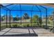Enclosed patio with views of lush landscaping and clear blue skies, offering a relaxing outdoor space at 12822 Del Corso Loop, Bradenton, FL 34211