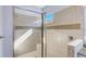 Close-up of tiled shower with glass door, built-in seat, and a window at 12822 Del Corso Loop, Bradenton, FL 34211