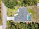Aerial view of a home with a screened pool, landscaped backyard, and mature trees, situated in a peaceful area at 1298 Russellville St, North Port, FL 34288