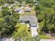 Beautifully landscaped home with a screened-in pool and well-maintained lawn, surrounded by mature trees at 1298 Russellville St, North Port, FL 34288