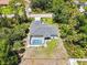 Aerial view of a home with a screened pool, green lawn, and lush tropical landscaping in a serene neighborhood at 1298 Russellville St, North Port, FL 34288