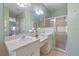 Bathroom featuring double sink vanity, framed mirror, and glass shower enclosure at 1298 Russellville St, North Port, FL 34288