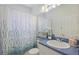 Charming bathroom featuring blue accents, a decorative shower curtain, and ample counter space at 1298 Russellville St, North Port, FL 34288