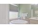 Bright bathroom featuring a garden tub, white cabinets, and a large window at 1298 Russellville St, North Port, FL 34288