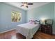 Cozy bedroom with hardwood floors, ceiling fan, and a large window with a lush view at 1298 Russellville St, North Port, FL 34288