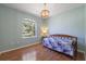 Bright bedroom with hardwood floors, a ceiling fan, and a large window with a lush view at 1298 Russellville St, North Port, FL 34288