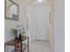 Bright foyer with neutral tones, decorative mirror, tiled floors and arched entryways at 1298 Russellville St, North Port, FL 34288